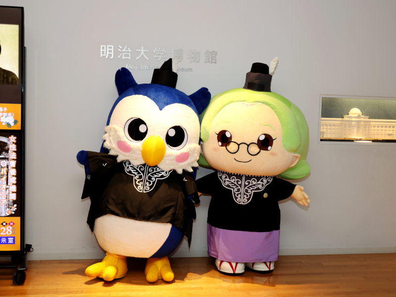中田正子さんをモデルとするマスコットキャラクター「まさこ先生」を、法服を着た明治大学公式キャラクター「めいじろう」が出迎えた
