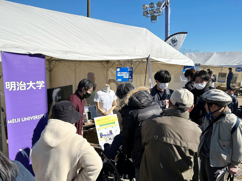 研究室の学生が来場者に展示ブースを紹介している様子